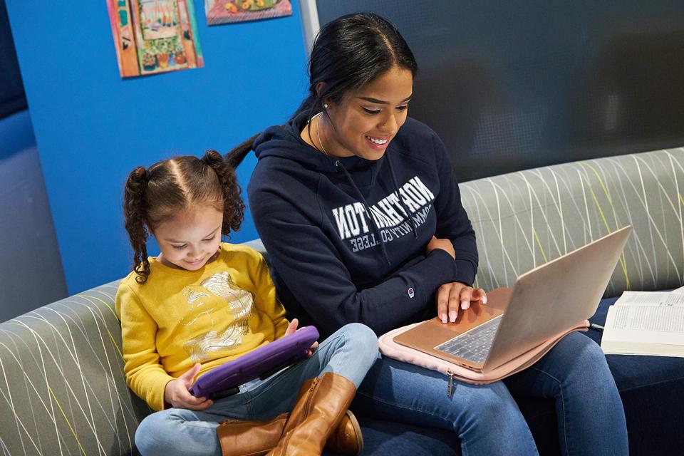 学生和她的女儿在玩电脑